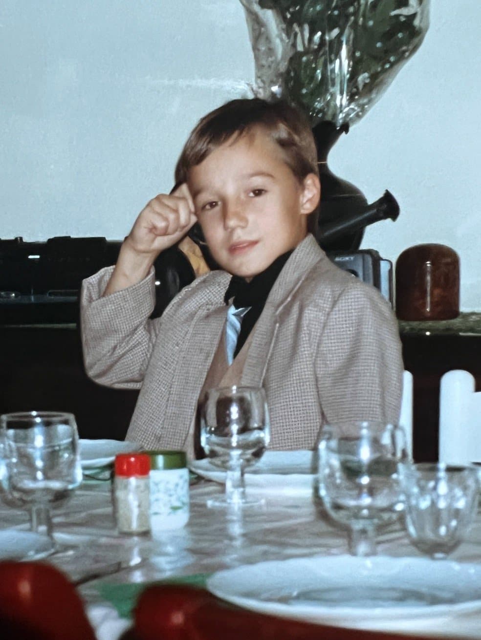 Victor da bambino, seduto a tavola in giacca e cravatta