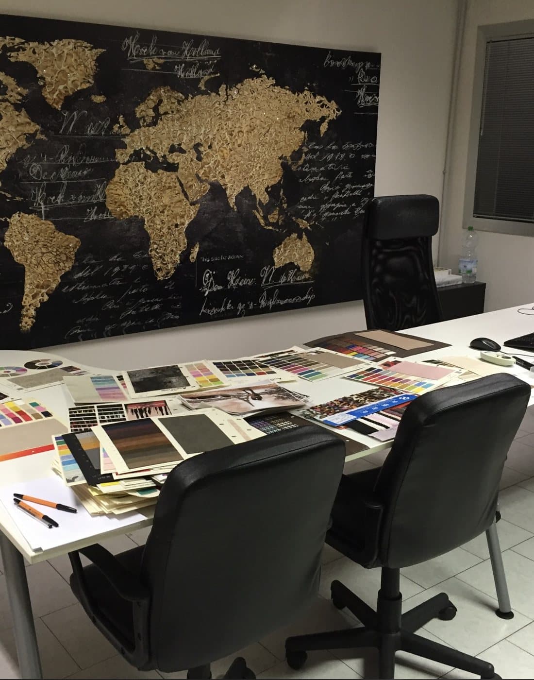 Il laboratorio di Fashion Mania con campioni di colore e grafiche sul tavolo